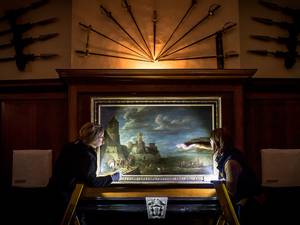 12 January 2015: A 17th Century painting is inspected using a raking light to check its condition before it is removed from Dyrham Park in Gloucestershire, so emergency conservation work can be carried out on the National Trust mansion house, England