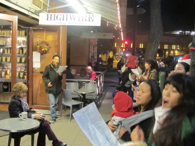 Protesters sing carols condemning police violence outside Rockridge Market Hall in Oakland. (Andrew Stelzer/KQED)