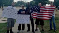 'Standing strong, in the face of terror! 21-year-old Joseph Offutt (in the middle) spent all day yesterday holding an American flag near the scene of Sunday night's shootout in Garland, TX. He says it's a message for ISIS and that his community will not 'give into' fear or back down to terror. As the day went on, several more patriots showed up to the scene and joined him with flags and signs.'