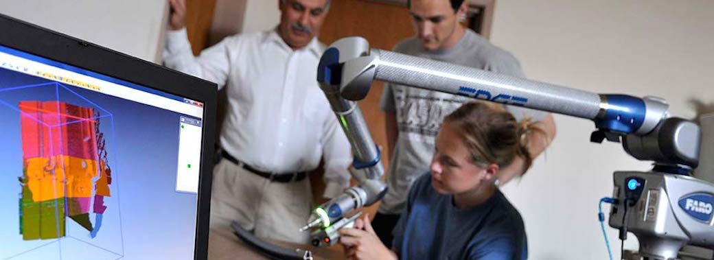 researchers operating a 3D scanner while viewing results on a monitor