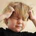 Photo of a boy scratching his head.