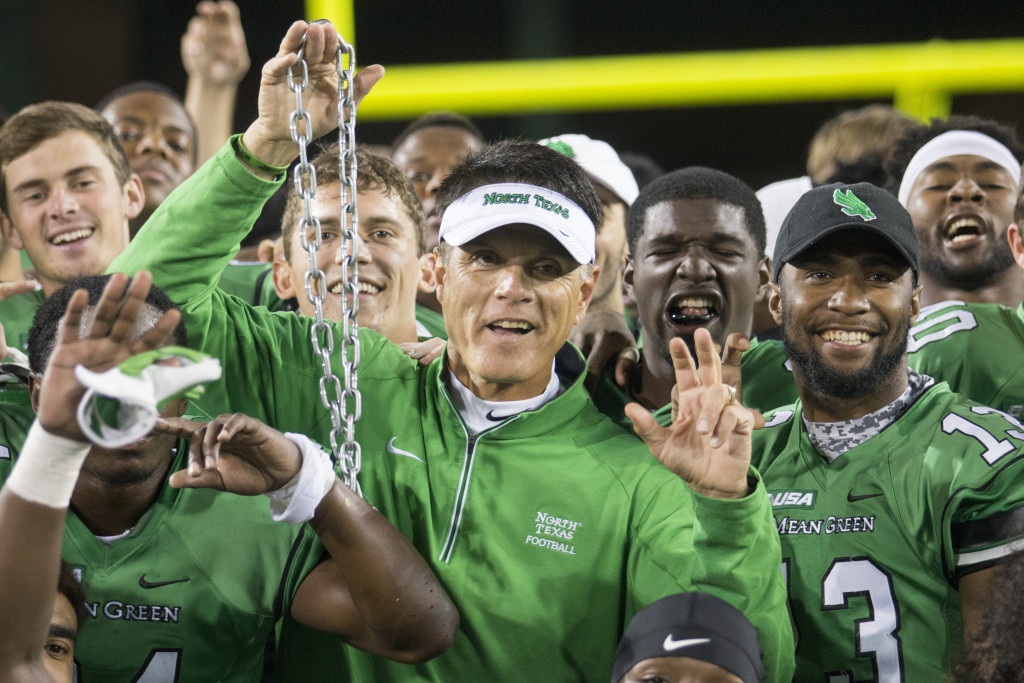 North Texas interm coach Mike Canales celebrates with the team after a 30­-23 victory over UTSA. Colin Mitchell | Intern Photographer