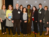 nine smiling people standing next to each other