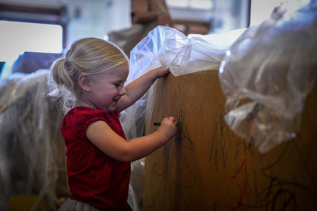 A young girl colors the side of a donation box that is being prepared for Operation Christmas Drop Dec. 5, 2015, at Andersen Air Force Base, Guam. During the humanitarian air drop mission, aircrews from the U.S., Japan and Australia will deliver a variety of donations to remote island residents via low-cost and low-altitude airdrops from C-130s. Children decorated the boxes to add their own holiday wishes for children on the islands. (U.S. Air Force photo by Staff Sgt. Alexander W. Riedel/Released)