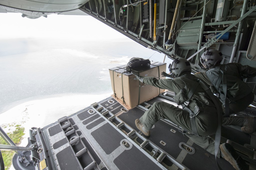 (Left to right) Maj. Bryan Huffman, Pacific Air Forces C-130 pilot, and Staff Sgt. Joel Powell, 36th Airlift Squadron loadmaster, drop a low-cost, low-altitude bundle to Ngulu island, Federated States of Micronesia, Dec. 11, 2015, during Operation Christmas Drop. This is a PACAF event which includes a partnership between the 374th Airlift Wing, Yokota Air Base, Japan; the 36th Wing, Andersen Air Force Base, Guam; the 734th Air Mobility Squadron, Andersen AFB of the 515th Air Mobility Operations Wing, Joint Base Pearl Harbor-Hickam. Hawaii; the University of Guam; and the Operation Christmas Drop private organization. It is the longest-running Department of Defense humanitarian airdrop operation with 2015 being the first trilateral execution with support from Japan Air Self-Defense Force and Royal Australian Air Force. (U.S. Air  Force photo by Osakabe Yasuo/Released)