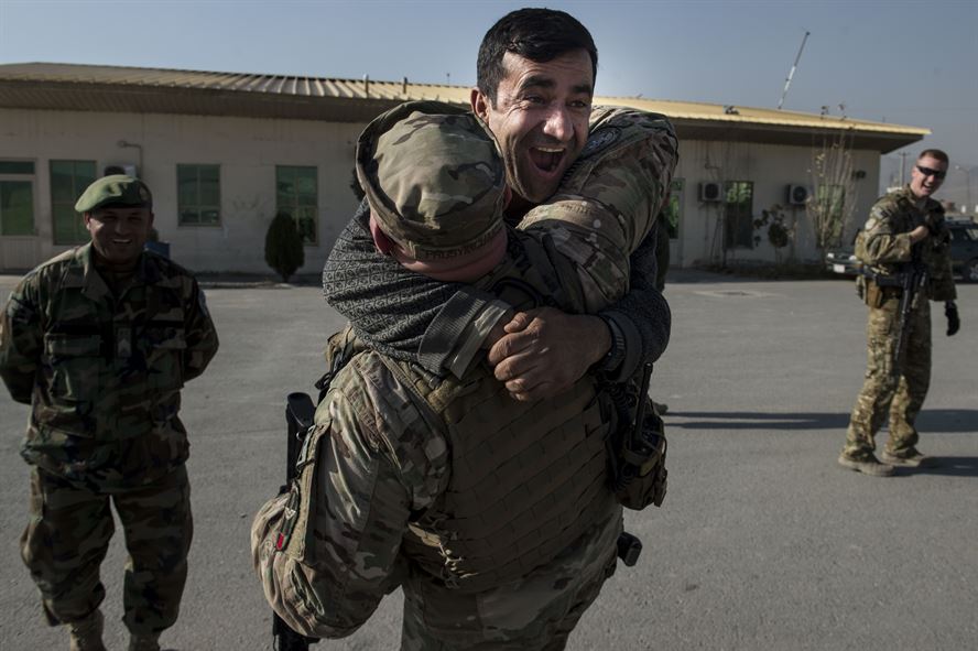 An Afghan air force member jumps into the arms of U.S. Air Force Master Sgt. Daniel Prosymchak near Forward Operating Base Oqab, Kabul, Afghanistan, Dec. 13, 2015. Prosymchak is assigned to the Train, Advise, Assist Command-Air security forces and is deployed from Joint Base Charleston, S.C. (U.S. Air Force photo/Staff Sgt. Corey Hook) 