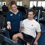 Health and wellness coach working with someone on a bike.