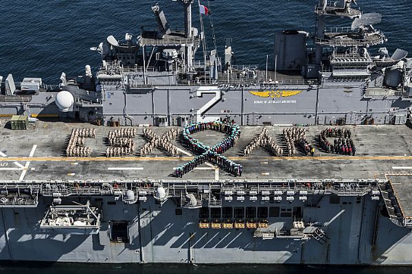 More than 630 Sailors, Marines and civilians aboard the Wasp-class amphibious assault ship USS Essex (LHD 2) form a teal ribbon and spell out "ESX ARG" to show support for Sexual Assault Awareness and Prevention Month. The formation was organized by the ship's sexual assault prevention and response (SAPR) victim advocates to kick-off the Sexual Assault Awareness and Prevention Month campaign and help raise awareness toward the importance of preventing sexual assault and other inappropriate behavior. Essex is underway participating in a composite training unit exercise with the Essex Amphibious Ready Group.  U.S. Navy photo by Mass Communication Specialist 3rd Class Huey D. Younger Jr. (Released)  150326-N-MD297-002