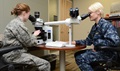 Air Force Lt. Col. Alice Briones and Navy Lt. Cmdr. Lisa Rivera examine tissue slides from organs in order to complete findings for an autopsy report. (Photo by Petty Officer 2nd Class Magan Delussey)