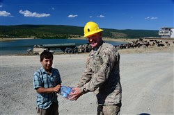 1st Sgt. Mike Ilko, 194th Engineer Brigade, Tennessee Army National Guard, shares bottled water with a young cattle herder Aug. 16, 2016, at Novo Selo Training Area, Bulgaria.  Local cattle and sheep herders regularly herd thier animals across NSTA.  Tennessee National Guard Soldiers and Airmen were on rotations to complete thier portions of projects as part of Operation Resolute Castle 16, an ongoing operation of military construction to build up Eastern European base infrastructure and help strengthen ties between Tennessee's state partnership with Bulgaria. (U.S. Air National Guard photo by Master Sgt. Kendra M. Owenby, 134 ARW Public Affairs)