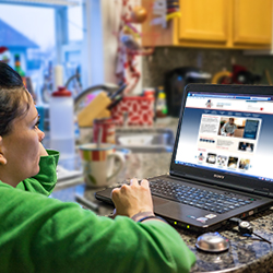 Woman looking at her laptop in the kitchen
