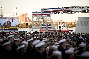 Brewer's Hill neighborhood of Baltimore can be seen in the background as Secretary of the Navy (SECNAV) Ray Mabus delivers remarks during the commissioning ceremony for the USS Zumwalt (DDG 1000).