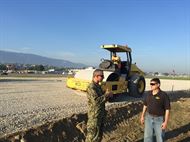 Navy Capt. Paul Haslam (left), commander of the DLA Rapid Deployment Team, discusses a project to build a helicopter pad with Troop Support liaison officer Robert Cunningham, Port-au-Prince, Haiti, October 2016.