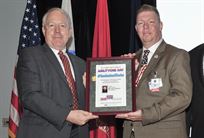 DLA Land and Maritime’s Acting Commander, James McClaugherty (left) presents a framed copy of the AbilityOne Day program to special guest speaker Scott Owens. Owens suffered a Traumatic Brain Injury during a combat tour in Iraq, and now represents AbilityOne through its Speaker's Bureau.