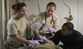 Medical personnel from the Air Force and Navy treat a simulated casualty during a mass casualty drill aboard the amphibious transport dock ship USS San Antonio. San Antonio is deployed with the Wasp Amphibious Ready Group to support maritime security operations and theater security cooperation efforts in the U.S. 5th Fleet area of operations.