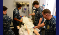 (Left to right) Navy Hospital Corpsman 3rd Class Michael Barber, Navy Hospital Corpsman 3rd Class Mashfik Hossain, Navy Hospital Corpsman 3rd Class Laurence Lau and Navy Cmdr. Trevor Carlson, Camp Geiger Branch Medical Clinic department head, work quickly to lower the simulated heat casualty’s body temperature. A core temperature of 107.5 can result in irreversible brain damage and 109 could result in a coma or death. (U.S. Navy photo by Danielle M. Bolton)