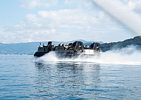 Landing Craft, Air Cushion (LCAC) 10, attached to Naval Beach Unit (NBU) 7 departs the tarmac for a routine flight.