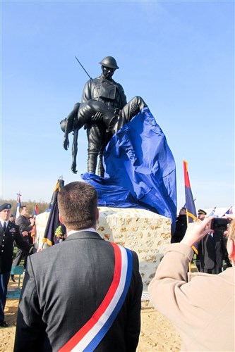 Soldiers of the 529th Military Police Company, 95th MP Battalion, 18th MP Brigade, look on with French citizens near Beuvardes, France, Nov. 12 during a special unveiling of the monument dedicated to the Soldiers of the 42nd Infantry division and who gave their lives in France during World War I. The memorial is a ten foot bronze sculpture of a Soldier carrying a fallen comrade.