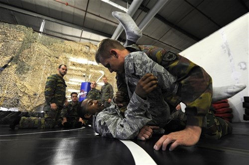 Air Force Staff Sgt. Christopher Whiting, 435th Security Forces Squadron Creek Defender instructor, demonstrates modified army combative technique to Belgian Army Sgt. Dennis Berkmans during a flyaway security team practice session on Dec. 07, 2011, Ramstein Air Base, Germany. As part of the 435th wing's Contingency Response Group, the 435th SFS contributes to the group's "open the base" mission, as well as expeditionary combat support training through the USAFE Security Forces Regional Training Center's Creek Defender course. 