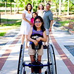Family with their daughter who is in a wheelchair.