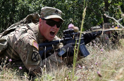 Staff Sgt. Daniel Dalton, squad leader with the 1st Battalion, 41st Infantry Regiment, 2nd Infantry Brigade Combat Team, shouts directions to his team during a squad level situational training exercise held in Dumnice, Kosovo, July 25, 2016. The purpose of the exercise was to train individual squad movements in preparation for a larger scale operation deemed Iron Eagle, later this year. (U.S. Army photo by: Staff Sgt. Thomas Duval, Multinational Battle Group-East Public Affairs)