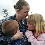 A Military mom hugging her two children