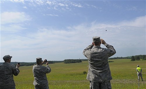 U.S. Air Force servicemembers observe a high altitude, low opening (HALO) jump from a C-130J Super Hercules during the opening ceremony for Allied Strike 2011, Grafenwoher Training Area, Germany, June 22, 2011. Allied Strike is Europe's premier Close Air Support exercise, held annually to conduct robust, realistic CAS training that helps build partnership capacity among Allied NATO nations and refine the latest operational CAS tactics. (U.S. Air Force photo by Airman 1st Class Desiree W. Esposito)
