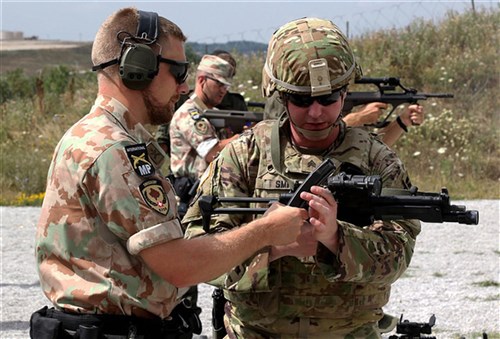 A member of the Kosovo Force (KFOR) International Military Police conducts preliminary marksmanship instruction with Sgt. Anthony Smith, a military policeman assigned to Multinational Battle Group-East, during a multinational marksmanship training exercise held on Camp Bondsteel, Kosovo, July 26, 2016. 
U.S. and NATO forces have contributed to the United Nations-mandated peacekeeping mission in Kosovo since June 1999. (U.S. Army photo by: Staff Sgt. Thomas Duval, Multinational Battle Group-East Public Affairs)