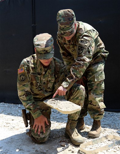 (Left-Right) Sgt. Michael Andresen and Sgt. Charles McElrath, both military policemen assigned to Multinational Battle Group-East, analyze a foot impression during a Crime Scene Investigation course held on Camp Bondsteel, Kosovo, July 13, 2016. (U.S. Army photo by: Staff Sgt. Thomas Duval, Multinational Battle Group-East public affairs)