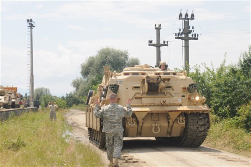 CINCU, Romania - A U.S. Soldier guides an M88 Hercules Recovery Vehicle as it backs-up along a dirt road in Viola, Romania July 5. The vehicle, belonging to the 116th Cavalry Brigade Combat Team (CBCT), Idaho Army National Guard is in Romania to be used during Exercise Saber Guardian 2016, which starts July 27. The 116th CBCT is one of the U.S. units participating in the exercise, which will also include forces from 11 different countries.