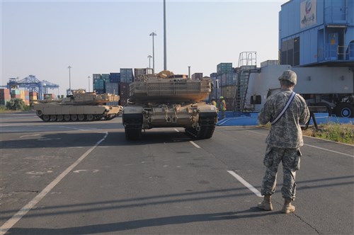 CONSTANTA, Romania - A U.S. Soldier guides M1A2 Abrams Tanks through the Port of Constanta June 25. The tanks, belonging to the 116th Cavalry Brigade Combat Team (CBCT), Idaho Army National Guard, arrived in Romania June 20, 2016 after being shipped via transport ship from Charleston Harbor, S.C. After being unloaded from the ship, the tanks were shipped via railcar to Cincu, Romania where they will be used by the brigade during Exercise Saber Guardian 2016, which starts July 27. Saber Guardian is a U.S. Army Europe-led exercise, in the spirit of partnership for peace. It is designed to promote regional stability and security, while strengthening partnership capacity, and fostering trust while improving interoperability between Romania, the U.S., NATO and Partnership for Peace member nations. The 116th CBCT is one of the U.S. units participating in the exercise, which will also include forces from 11 different countries.