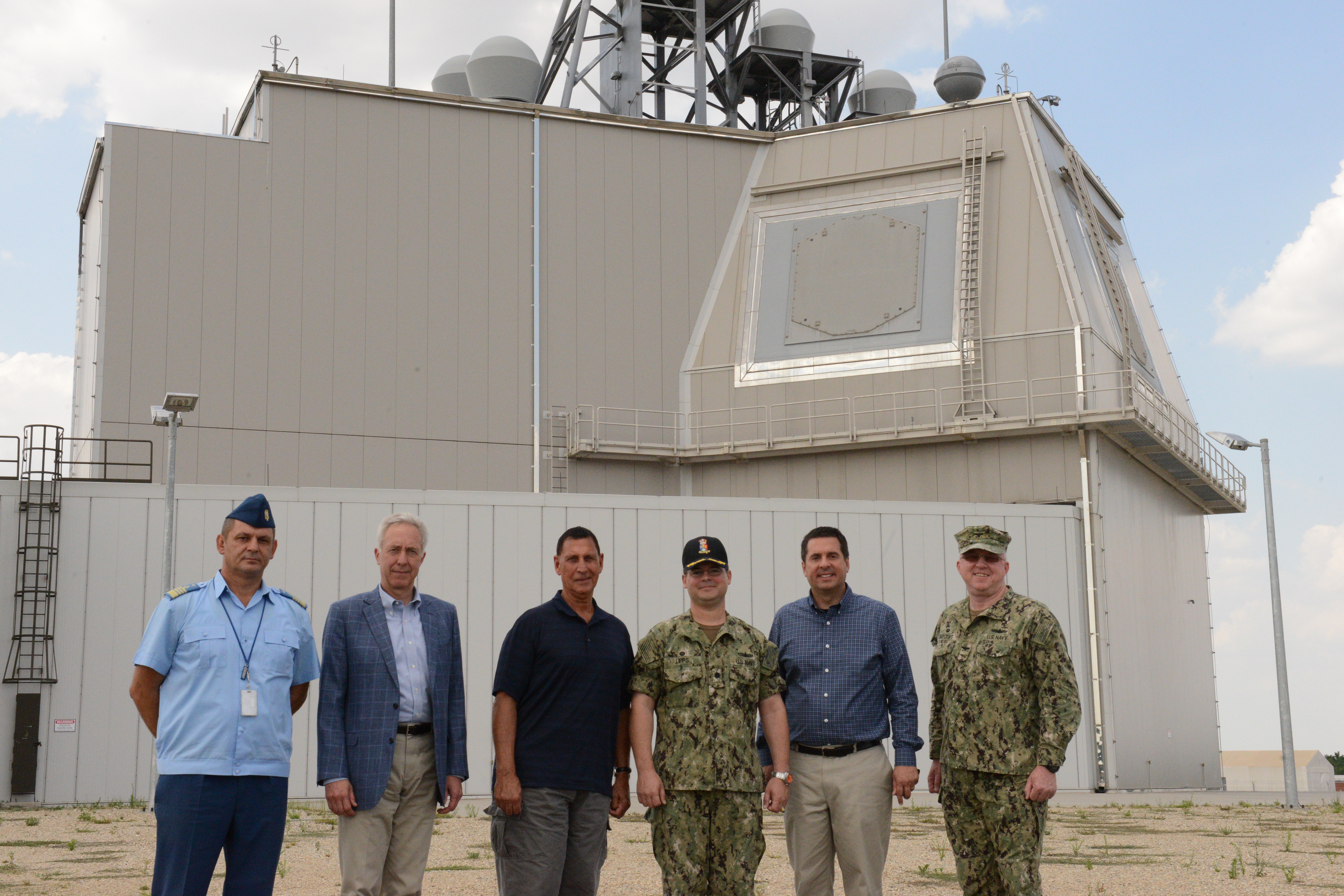 DEVESELU, Romania (Aug. 6, 20-16) Members of the House Permanent Select Committee on Intelligence, stop to take a photo in front of the Aegis Ashore Missile Defense System (AAMDS) deckhouse during their recent visit to Naval Support Facility (NSF) Deveselu and AAMDS Romania. (U.S. Navy Photo by Lt. Travis Christensen/Released)