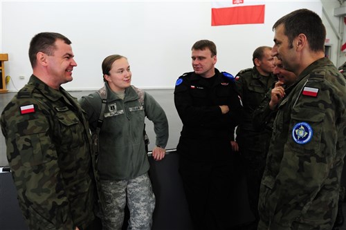 Capt. Barbara Bujak, physical therapist at Landstuhl Regional Medical Center, speaks in her native tongue, Polish, with members of Multinational Battle Group East's Polish Contingent and European Rule of Law Mission in Kosovo. Bujak, who was born in Poland, moved to the U.S. at age 11 and joined the U.S. Army five years ago. Bujak's temporary assignment at Camp Bondsteel allowed her to experience a familiar ceremony in a new location. 