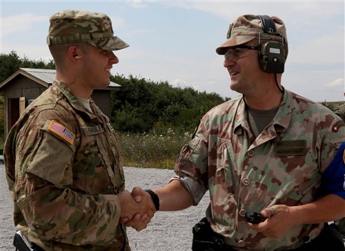 Sgt. Kai Fariss, a military policeman assigned to Multinational Battle Group-East, shakes hands with a member of the Kosovo Force (KFOR) International Military Police during a multinational marksmanship training exercise held on Camp Bondsteel, Kosovo, July 26, 2016. U.S. and NATO forces have contributed to the United Nations-mandated peacekeeping mission in Kosovo since June 1999.
(U.S. Army photo by: Staff Sgt. Thomas Duval, Multinational Battle Group-East Public Affairs)