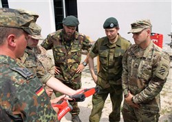 Staff Sgt. Craig Pruden, a combat engineer with 10th Engineer Battalion, 1st Armored Brigade Combat Team, 3rd Infantry Division, listens as German Soldiers talk about different equipment they use to assess bridges during a an International Bridge Assessment Course at Ingolstadt, Germany July 12. The course, a bilateral project from the Belgian and German engineer schools, supported by the Military Engineering Centre of Excellence, aims to inform Soldiers on the different existing bridge assessment methods.