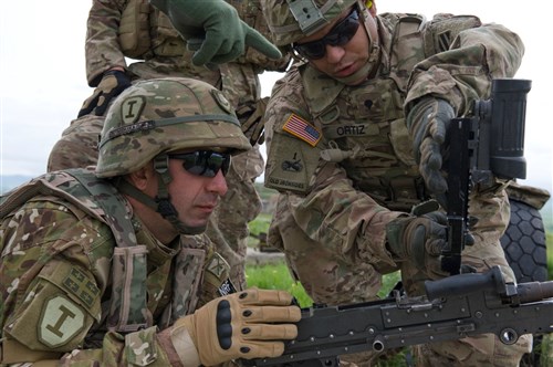 Spc. Ramon Ortiz, an infantryman assigned to Company A, 2nd Battalion, 7th Infantry Regiment, 1st Brigade, 3rd Infantry Division, trains a Georgian soldier on how to clear empty shell rounds from the loading tray of a M240B during clearing procedures May 14, 2015. Noble Partner is a field training and live-fire exercise between the U.S. Army and the Georgian military to support Georgia's participation in the NATO Response Force and build military ties between the two nations. (U.S. Army Photo by Sgt. Daniel Cole, Army Europe Public Affairs)