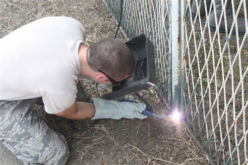 Senior Airman Nicholas Dotson, a member of the 200th RED HORSE Squadron and a Mansfield, Ohio, native, uses an arc welder to attach together two pieces of fence, Aug. 7, 2012, at the Svetozar Markovic Primary School in Kraljevo, Serbia. The 200th RED HORSE Armen are conducting a joint construction mission with talong with Ohio Army National Guard and Serbian 2nd Army Brigade engineers to repair the Svetozar Markovic Primary School, which was damaged by an earthquake in late 2010. 