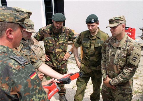 Staff Sgt. Craig Pruden, a combat engineer with 10th Engineer Battalion, 1st Armored Brigade Combat Team, 3rd Infantry Division, listens as German Soldiers talk about different equipment they use to assess bridges during a an International Bridge Assessment Course at Ingolstadt, Germany July 12. The course, a bilateral project from the Belgian and German engineer schools, supported by the Military Engineering Centre of Excellence, aims to inform Soldiers on the different existing bridge assessment methods.