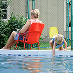 Mother and young child next to a swimming pool.