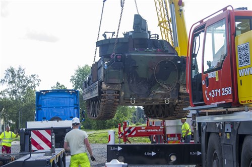 Latvian civilian contractors transfer an M2A2 Bradley Fighting Vehicle (BFV) from train to trailer at the rail yard in Garkalnes, Latvia on July 9, 2016. Latvian contractors are working with soldiers from the 386th Transportation Detachment, 39th Transport Battalion who provide movement control for 3rd Battalion, 69th Armored Regiment. Soldiers from 3rd Battalion are training with their Latvian allies in support of Operation Atlantic Resolve which is being conducted in Eastern Europe to demonstrate U.S. commitment to the collective security of NATO and dedication to enduring peace and stability in the region.