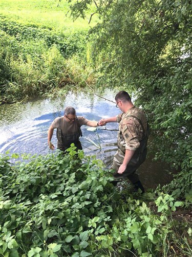 U.S. Army 1st Lt. Graham Hill, an engineer with the 10th Engineer Battalion, 1st Armored Brigade Combat Team, 3rd Infantry Division, helps a German Soldier get out of a creek as they assess a bridge near Ingolstadt, Germany July 14. Soldiers from the battalion joined engineers from 11 NATO countries and a Partner for Peace country for an International Bridge Assessment Course aimed at informing Soldiers on the different existing bridge assessment methods.