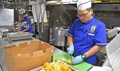 Navy Culinary Specialist Seaman Peng Yan, from Los Angeles, prepares oranges in the galley aboard the guided-missile destroyer USS Stockdale. 
