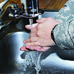 Service member washing his hands.