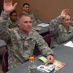 Service members raising hands in a class