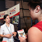 Two women talking at a Military Spouse Employment Partnership table