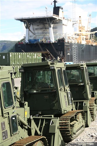 Military bulldozers and other equipment are staged for transportation at the designated offload pier during a pre-planned Single Ship Movement and offload of military equipment from a Maritime Prepositioning Force ship in the Trøndelag region of Norway.
 
U.S. Marines from 2nd Marine Logistics Group out of Camp Lejeune, NC, in coordination with their Norwegian counterparts, are modernizing some of the equipment currently stored within six caves as a part of the Marine Corps Prepositioning Program-Norway by placing approximately 350 containers of gear and nearly 400 pieces of heavy rolling stock into the storage caves. 

Specific equipment which will greatly increase the program's readiness includes M1A1 Main Battle Tanks, Tank Retrievers, Armored Breeching Vehicles, Amphibious Assault Vehicles, Expanded Capacity Vehicle (ECV) Gun Trucks and several variants of the MTVR 7-1/2 ton trucks.