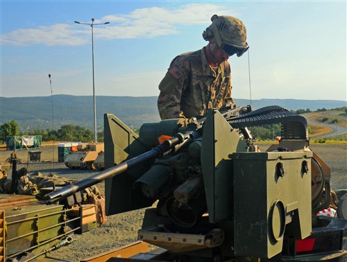 NOVO SELO TRAINING AREA, Bulgaria – Spc. Jonathan Cyr, Anvil Company, 1st Combined Arms Battalion, 64th Armor Regiment mounts a 50 caliber machine gun onto a M1A2 Abrams tank, July 21, 2016 before heading out to the field for training. 1st Bn., 64th Arm. Rgmt. is in Bulgaria in support of Operation Atlantic Resolve, a U.S. led effort in Eastern Europe that demonstrates U.S. commitment to the collective security of NATO and enduring peace and stability in the region.