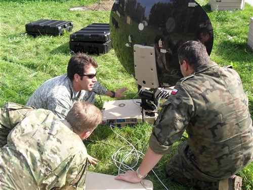 A noncommissioned officer, second from left, assigned to Special Operations Command Europe Signal Detachment explains how to set up a commercial satellite dish to Polish communications officers on Sept. 24 at the 21st Tactical Airbase in Swidwin, Poland as part of the Jackal Stone 10 exercise. Jackal Stone is an annual international special operations forces (SOF) exercise held in Europe. Its objective is to enhance capabilities and interoperability amongst the participating special operations forces as well as build mutual respect while sharing doctrinal concepts. The exercise, which is coordinated by U.S. Special Operations Command Europe, includes Poland, Lithuania, Latvia, Croatia, Romania, and Ukraine. (U.S. Army photo by Capt. Matthew Songy - photo approved for public release by SOCEUR PAO - MAJ James Gregory)
