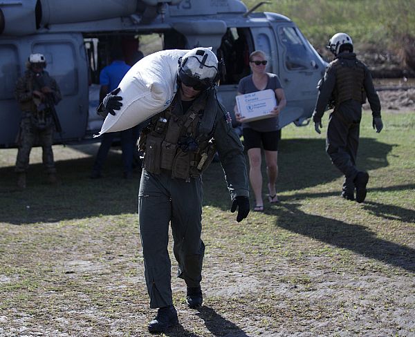 Sailors with Helicopter Sea Combat Squadron 28, civil aid workers and local Haitian villagers unload supplies from an MH-60 Seahawk in the aftermath of Hurricane Matthew at LaCohaune, Haiti. USAID is coordinating aid with the U.S. military, other international partners, such as the WFP, and non-governmental organizations to provide relief to the people of Haiti. The 24th Marine Expeditionary Unit is committed to providing support where it is needed while continuing to prepare for their upcoming deployment.  U.S. Marine Corps photo by Sgt. Justin T. Updegraff (Released)  161017-M-TV331-084