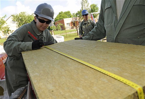 Staff Sgt. Amanda Turnwald, 127th Civil Engineering Squadron engineering assistant, marks a measurement on a piece of rock wool insulation at a kindergarten in Silmala, Latvia on June 23, 2016. The school is currently undergoing a Humanitarian-civic assistance project to provide the school with up to date renovations. (U.S. Air National Guard photo by Senior Airman Ryan Zeski)